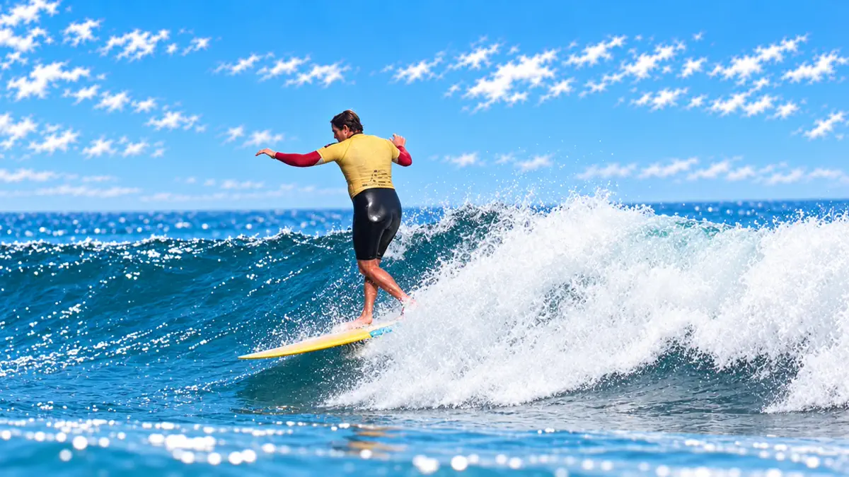 A longboarder walking forward on the board along the face of a clean wave